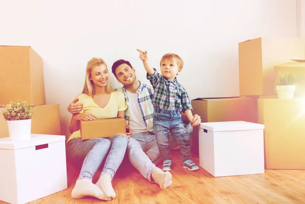 Счастливая семья с коробками переезжает в новый дом — стоковое фото