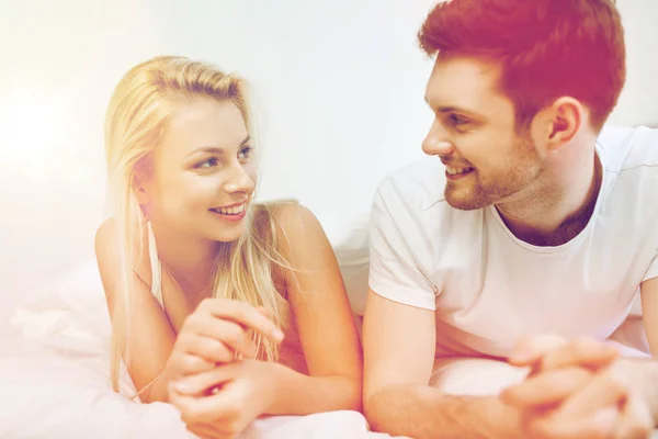 Casal feliz deitado na cama em casa — Fotografia de Stock