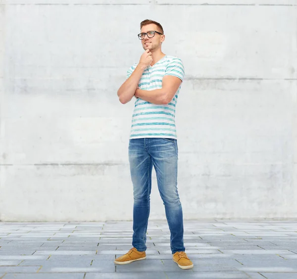 Lachende jongeman in brillen denken — Stockfoto