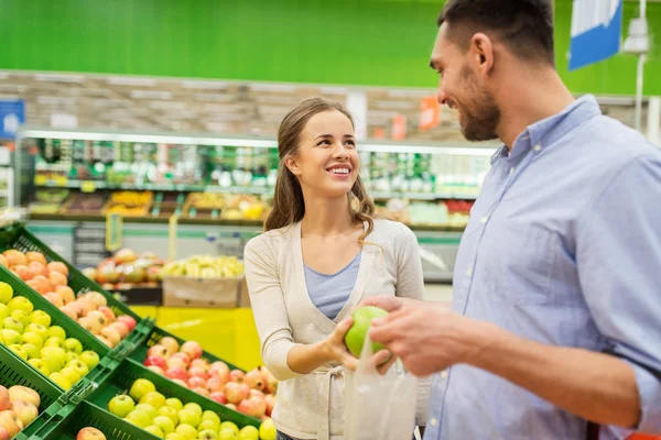 Lyckliga paret att köpa äpplen vid livsmedelsbutik — Stockfoto