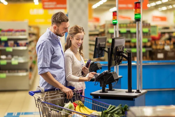 Paar voedsel bij supermarkt bij kassa kopen — Stockfoto