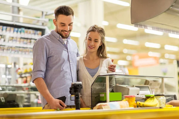Casal comprando alimentos na loja de mercearia caixa registradora — Fotografia de Stock