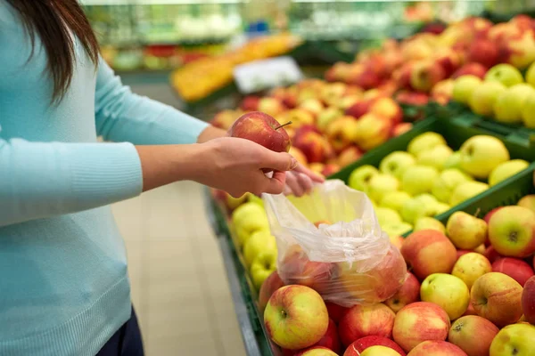 Woman with bag buying apples at grocery store — Stock Photo, Image