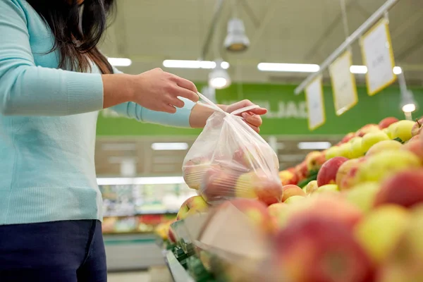 Woman with bag buying apples at grocery store — Stock Photo, Image