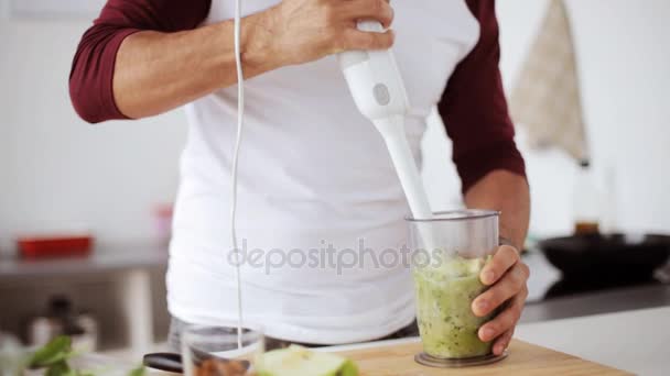 Muž s mixérem vaření smoothie v domácí kuchyni — Stock video