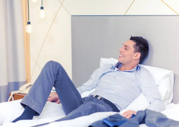 ホテルの部屋でベッドに横たわっている幸せの実業家 — ストック写真