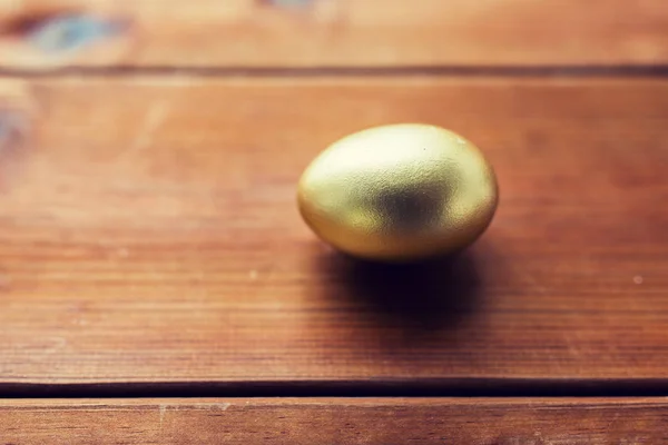 Primo piano di uovo di Pasqua d'oro su legno — Foto Stock