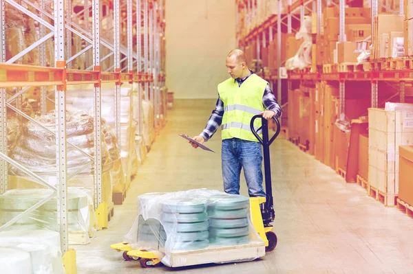 Man met lader en Klembord in magazijn — Stockfoto