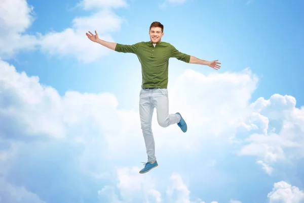 Smiling young man jumping in air — Stock Photo, Image