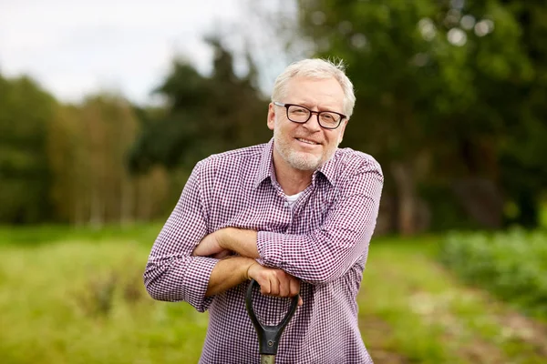 Ευτυχής χαμογελαστοί ανώτερος άνθρωπος με εργαλείο κήπου στο αγρόκτημα — Φωτογραφία Αρχείου