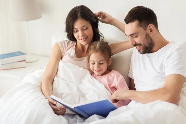 Ευτυχισμένη οικογένεια ανάγνωση βιβλίων στο κρεβάτι στο σπίτι — Φωτογραφία Αρχείου