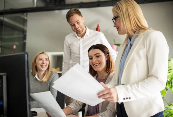 Happy creative team with papers in office — Stock Photo, Image