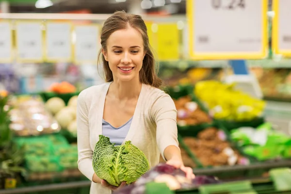 Счастливая женщина покупает колбасу в продуктовом магазине — стоковое фото