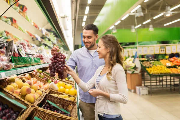 Glückliches Paar kauft Trauben im Lebensmittelgeschäft — Stockfoto