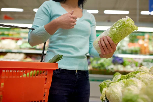 Woman with basket and chinese cabbage at grocery — Stock Photo, Image