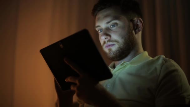 Hombre joven con la tableta ordenador PC por la noche — Vídeos de Stock