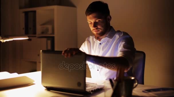 Man with laptop finishing work at night office — Stock Video