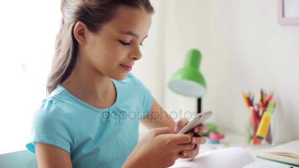 Χαμογελαστό κορίτσι γραπτών μηνυμάτων στο smartphone στο σπίτι — Αρχείο Βίντεο