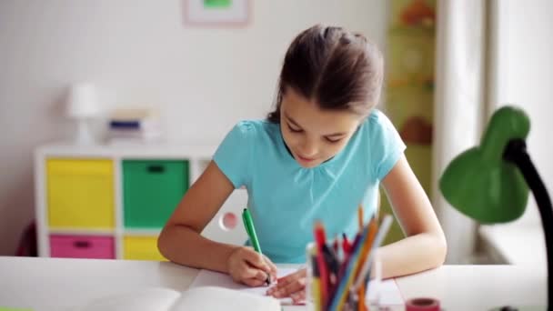 Χαρούμενο κορίτσι με το γράψιμο βιβλίων στο σημειωματάριο στο σπίτι — Αρχείο Βίντεο