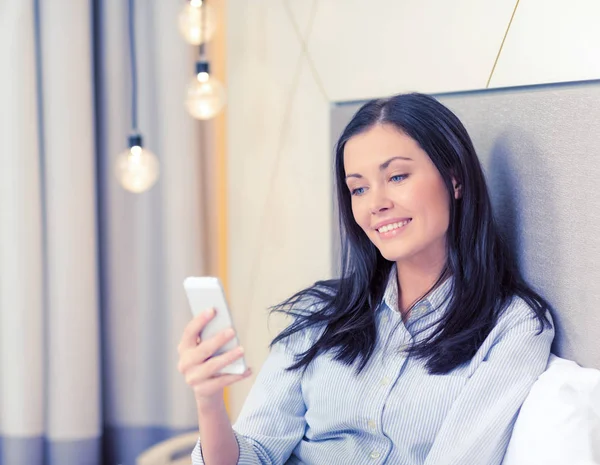 Empresária feliz com smartphone no quarto de hotel — Fotografia de Stock