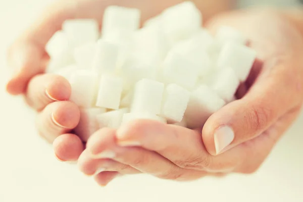 Nahaufnahme von weißem Klumpen Zucker in Frauenhänden — Stockfoto