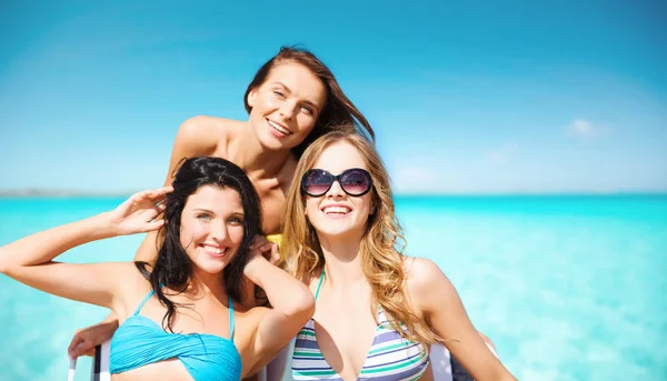 Gelukkige jonge vrouwen in bikini 's op het zomerstrand — Stockfoto