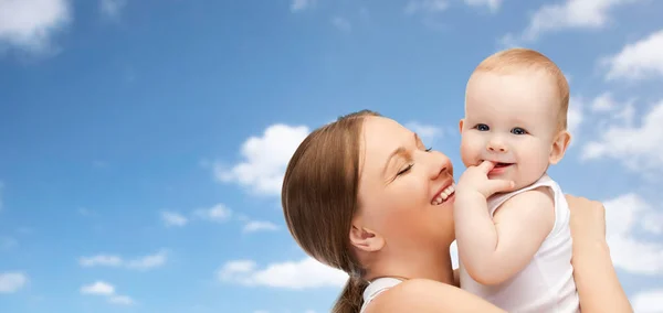 Feliz madre sosteniendo adorable bebé sobre el cielo azul —  Fotos de Stock