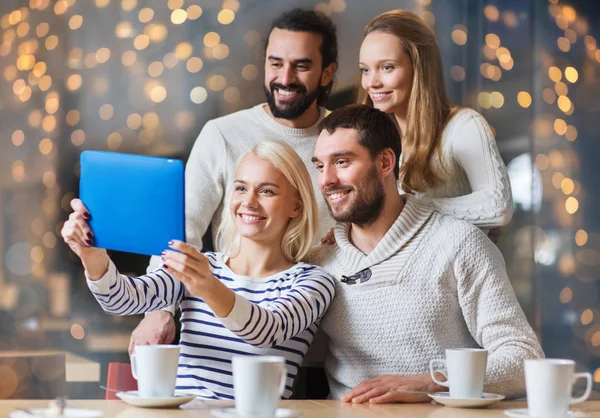 Happy friends with tablet pc taking selfie at cafe — Stock Photo, Image