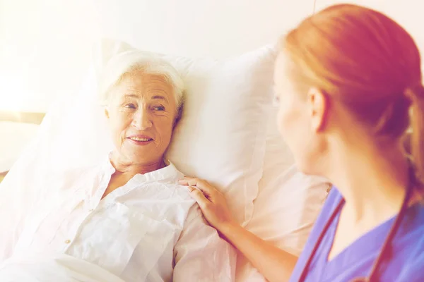 Médecin ou infirmière visitant une femme âgée à l'hôpital — Photo