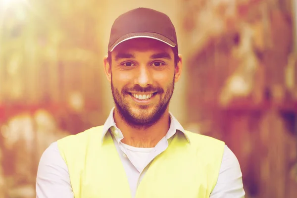 Happy man in reflective safety vest at warehouse — Stock Photo, Image