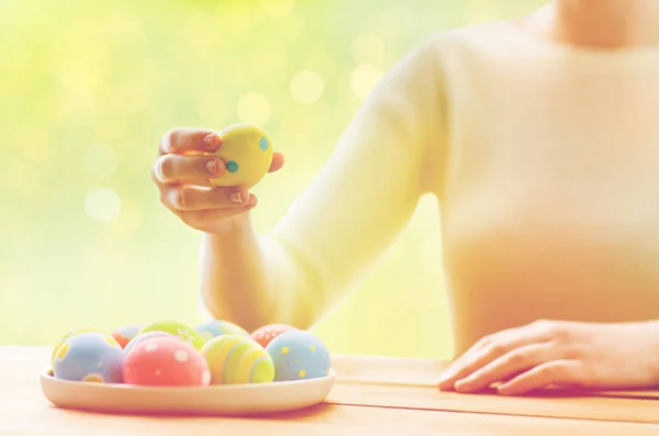 Close up de mãos de mulher com ovos de páscoa coloridos — Fotografia de Stock