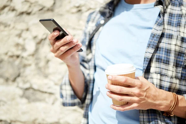 Человек со смартфоном и кофе на городской улице — стоковое фото
