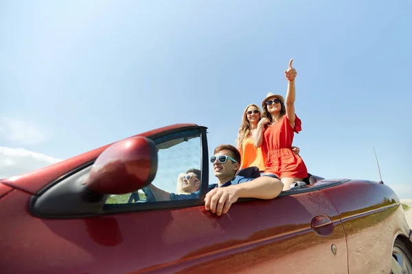 Happy friends driving in cabriolet car at country — Stock Photo, Image