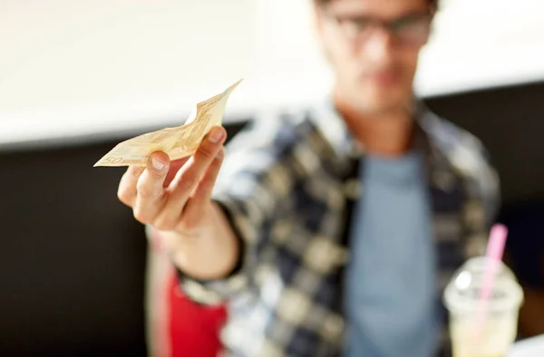 Lycklig man med kontanta pengar betala på café — Stockfoto