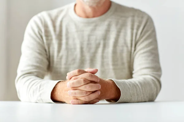 Perto de mãos de homem sênior na mesa — Fotografia de Stock