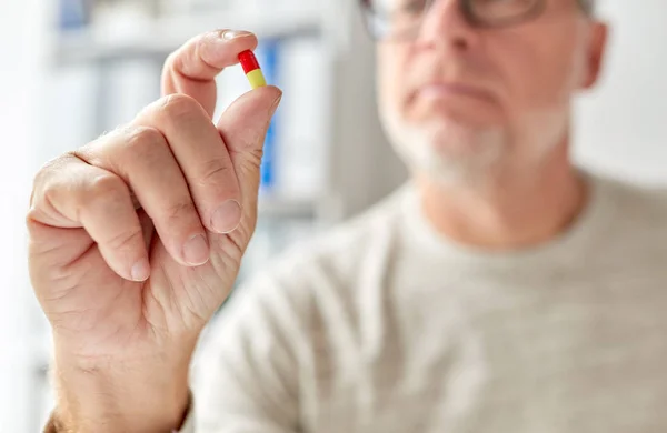 Close up of old man hand with pill — Stock Photo, Image