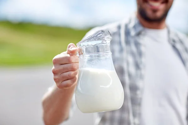 Hombre o agricultor con jarra de leche en el campo — Foto de Stock