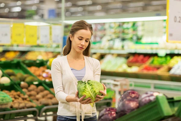 Happy woman buying savoy at grocery store — Stock Photo, Image