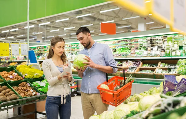 Casal com comida cesta compras no supermercado — Fotografia de Stock