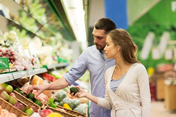 Casal feliz comprando abacate no supermercado — Fotografia de Stock