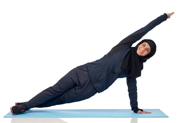 Muslimische Frau treibt Sport auf Matte — Stockfoto