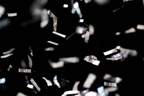 Silbernes Konfetti auf schwarzem Hintergrund — Stockfoto