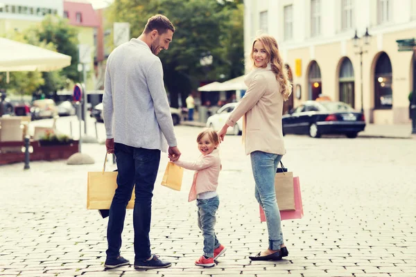 Famiglia felice con bambino e shopping bag in città — Foto Stock