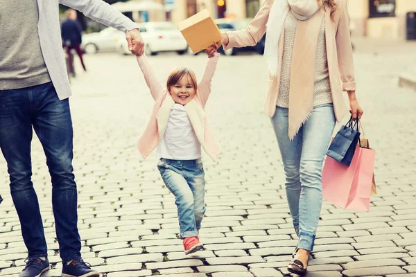 Família feliz com criança e sacos de compras na cidade — Fotografia de Stock