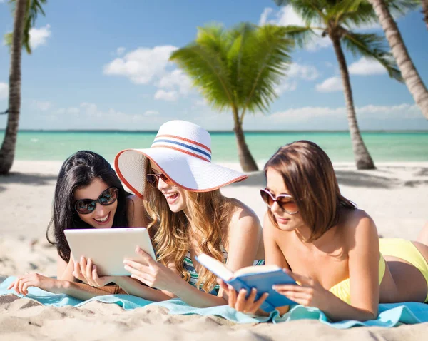 Mulheres com tablet pc e livro na praia de verão — Fotografia de Stock