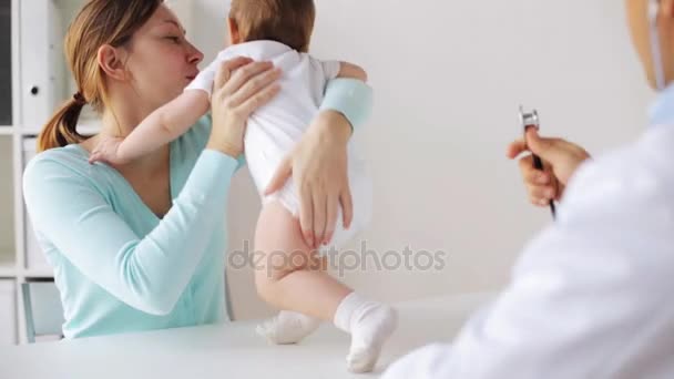 Médico con estetoscopio revisando al bebé en la clínica — Vídeos de Stock