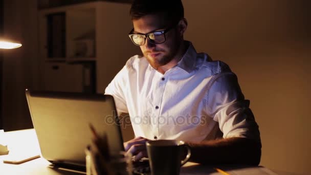 Hombre con laptop y papeles trabajando en la oficina nocturna — Vídeos de Stock