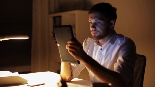 Hombre con tablet pc trabajando hasta tarde en la noche en la oficina — Vídeos de Stock