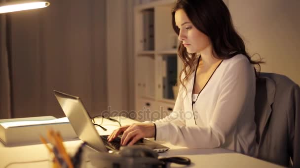 Woman with laptop calling on phone at night office — Stock Video