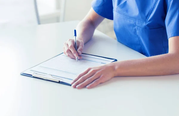 Închiderea scrisului medicului sau asistentei medicale în clipboard — Fotografie, imagine de stoc